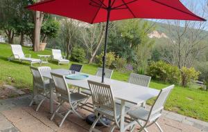 einen Tisch und Stühle mit einem roten Regenschirm in der Unterkunft Nice Apartment In Erbalunga With Wifi in Erbalunga + 20 Fotos