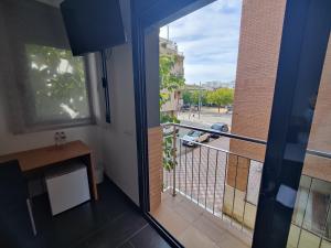 a room with a balcony with a view of a street at Hostal Manel in Pineda de Mar