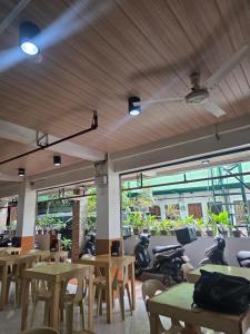 a restaurant with wooden tables and chairs and windows at Aosmec Square Hotel in Mactan