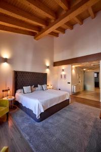 パルマ・デ・マヨルカにあるHotel Bosch Boutiqueの大きなベッドと木製の天井が備わる広いベッドルーム1室が備わります。