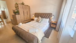 een slaapkamer met een bed en een bank bij Bali Beach Flats, Muizenberg in Kaapstad