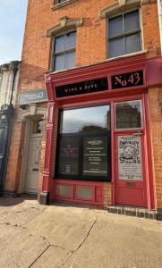 een bakstenen gebouw met een rode deur op een straat bij Worcester City Centre self check-in cosy loft apartment in Henwick