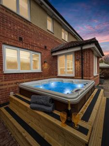 un bain à remous sur une terrasse en face d'une maison dans l'établissement Amaya Eight - Large 5 Bedroom - 3 Bathroom house - garden and driveway, à Claypole