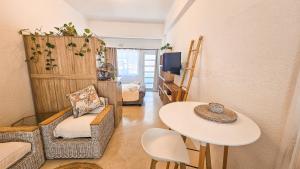 een kleine woonkamer met een tafel en een tafel en een tafel bij Bali Beach Flats, Muizenberg in Kaapstad