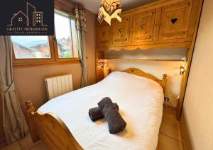 een teddybeer op een bed in een kamer bij Chaleureux 2 chambres, Morillon in Morillon