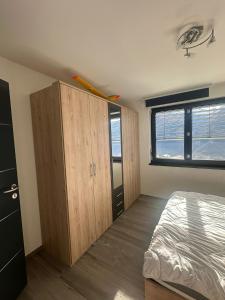 Un dormitorio con una cama y un gran armario de madera. en Chambres dans villa à 10 minutes de Crans-Montana, en Chermignon-dʼen Haut