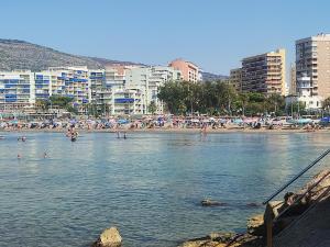 a group of people in the water at a beach at APCOSTAS Palmavera Playa de la Conxa in Oropesa del Mar