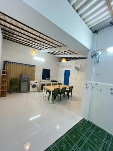 Una habitación con una mesa y sillas y una cocina. en LUA Homestay, en Vĩnh Long