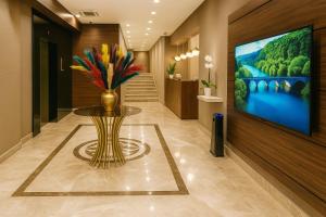 un vestíbulo con un jarrón de flores sobre una mesa en Grand Canyon Hotel, en Ankara 20 fotos más