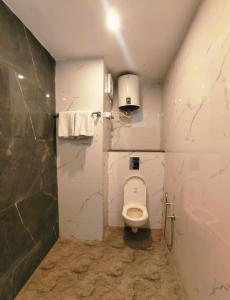 a small bathroom with a toilet and a shower at Green View in Mussoorie