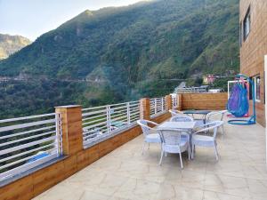 a balcony with tables and chairs and a mountain at Green View in Mussoorie