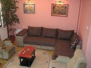 ein Wohnzimmer mit einem Sofa und einem Tisch in der Unterkunft Guest House Trajkovic in Jagodina