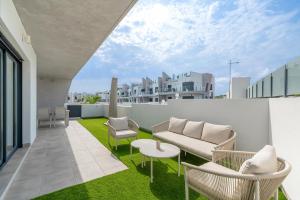 a patio with a couch and chairs on a balcony at Casa Jette in San Miguel de Salinas