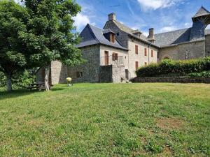 a large stone building with a grass yard at Gîte de la Capelle in Touluch