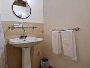 a bathroom with a sink and a mirror and towels at Gîte de la Capelle in Touluch