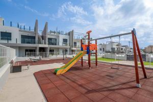 a playground with a slide in front of a building at Casa Jette in San Miguel de Salinas
