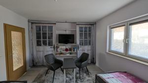 ein Wohnzimmer mit Tisch und Stühlen und einem Fernseher in der Unterkunft Ferienwohnung Schusi Kesselsdorf in Kesselsdorf + 6 Fotos