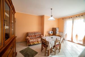 a dining room with a table and a couch at Residence dei fiori - Dimora Mery in Pontecchio Polesine