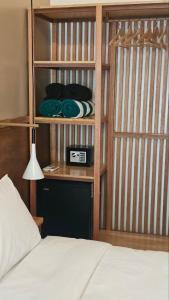 a bedroom with a bed and a shelf with a clock at Pearl Villa in Fulhadhoo