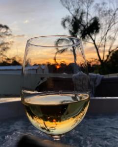 ein Glas Wein auf einem Tisch mit Sonnenuntergang in der Unterkunft Ella Cottage - Relaxing romantic escape-Southern Highlands 
