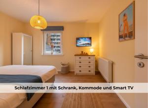 Un dormitorio con una cama y una cómoda y una ventana. en Utes Huus, en Wyk auf Föhr