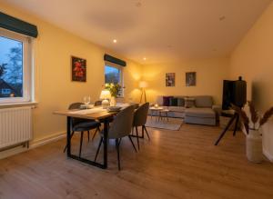 Una sala de estar con una mesa y sillas y un sofá. en Utes Huus, en Wyk auf Föhr