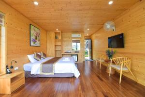a bedroom with a bed and a desk and a television at San Signature - Suối Ngọc Retreat in Tien Xuan