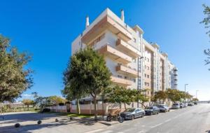 un grand immeuble dans une rue avec des voitures garées dans l'établissement Apartamento Novomar By Solymar Holiday, à Torre del Mar