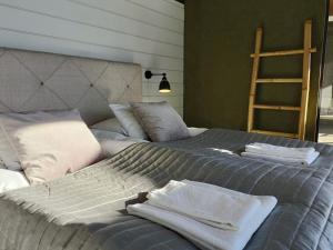a bedroom with two beds with towels on them at Top-equipped Kaarna Spa Villa in Inhantehtaat +12 photos