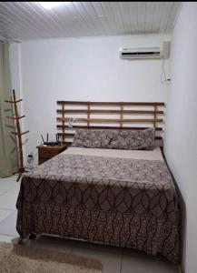 ein Schlafzimmer mit einem Bett und einem Nachttisch in der Unterkunft casa dos MORAIS in Angra dos Reis