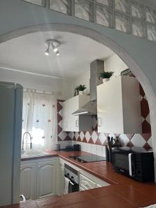 a kitchen with white cabinets and a microwave at Casa Tortuga 1era linea de playa in Alcalá