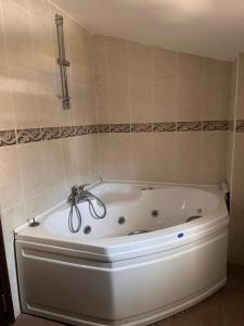 eine weiße Badewanne im Bad mit einer Kachelwand in der Unterkunft Marvelous Seaview Villa Lemon Kalkan in Kalkan