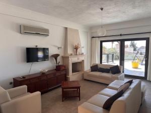 ein Wohnzimmer mit Sofa und Fernseher in der Unterkunft Marvelous Seaview Villa Lemon Kalkan in Kalkan