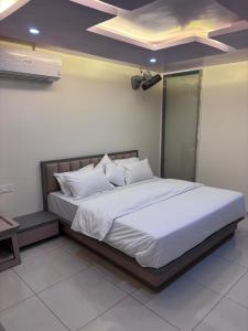 Un dormitorio con una cama grande con sábanas blancas. en NR Hotel, en Rīngas 2 fotos más