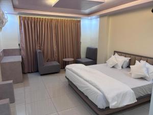 Un dormitorio con una cama, una silla y una ventana en NR Hotel, en Rīngas