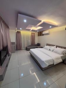 Un dormitorio con una cama grande y un televisor. en NR Hotel, en Rīngas