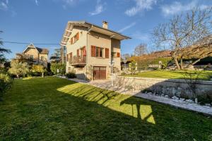 une maison avec une cour verte avec un étang dans l'établissement Maison de charme - Vues Montagnes - Aix-les-Bains, à Aix-les-Bains