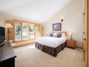 um quarto com uma cama grande e uma televisão em RMR: Tram Tower 12 Condo in Teton Village em Teton Village