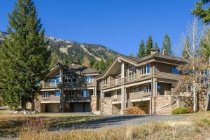 uma casa grande com uma montanha ao fundo em RMR: Tram Tower 12 Condo in Teton Village em Teton Village