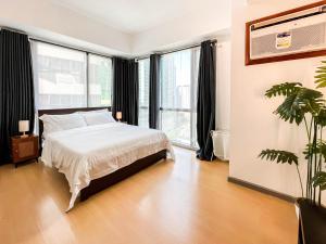 Sampongcorner 1BR unit with city view Avant at The Fort的一间卧室，里面有一张床和一扇大窗户。
