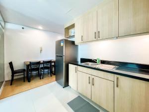 Sampongcorner 1BR unit with city view Avant at The Fort的厨房配有木制橱柜和桌椅