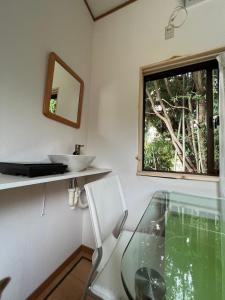 baño con mesa de cristal y ventana en Oasis Minamiboso, en Minamiboso