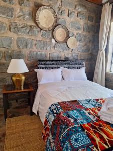 ein Schlafzimmer mit einem Bett und einer Steinwand in der Unterkunft Kiserian cottage with gazebo garden grill - 2343 in Kiserian