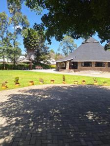 einen Backsteinsteg vor einem Gebäude in der Unterkunft Kiserian cottage with gazebo garden grill - 2343 in Kiserian