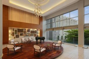 a living room with a grand piano and chairs at Sheraton Kosgoda Turtle Beach Resort in Bentota