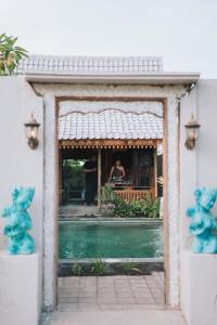 Eine Frau sitzt an einem Tisch in einem Haus in der Unterkunft Villa Soluna Lovina in Lovina
