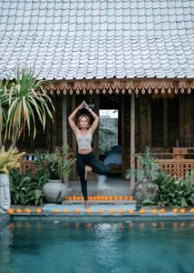 Eine Frau macht Yoga am Pool in der Unterkunft Villa Soluna Lovina in Lovina