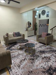 ein Wohnzimmer mit 2 Sofas und einem Teppich in der Unterkunft coach homestay 2 in Kuantan