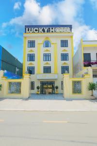 a yellow building with a sign on top of it at Lucky Hotel Uông Bí in Uông Bí