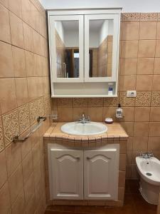 a bathroom with a sink and a mirror and a toilet at Casa Tortuga 1era linea de playa in Alcalá +43 photos